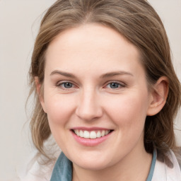 Joyful white young-adult female with medium  brown hair and blue eyes