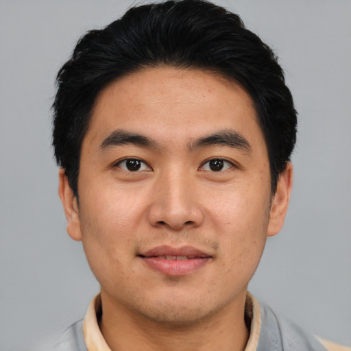 Joyful asian young-adult male with short  black hair and brown eyes