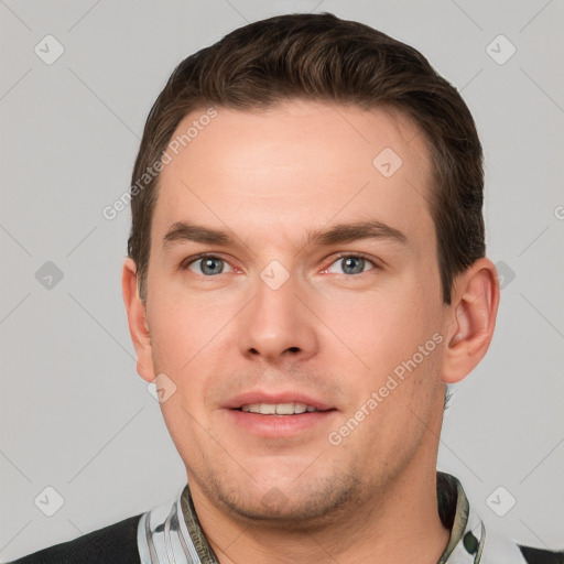 Joyful white young-adult male with short  brown hair and grey eyes