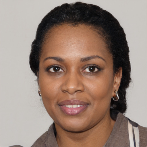Joyful black young-adult female with short  black hair and brown eyes