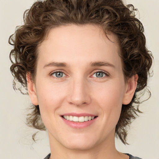 Joyful white young-adult female with medium  brown hair and green eyes