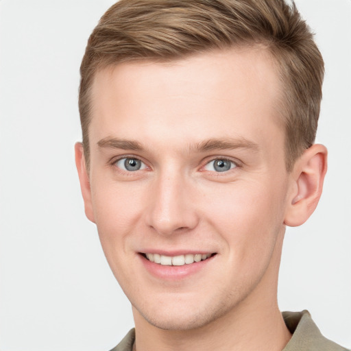 Joyful white young-adult male with short  brown hair and grey eyes