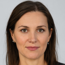 Joyful white adult female with long  brown hair and brown eyes