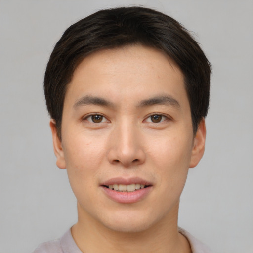 Joyful asian young-adult male with short  brown hair and brown eyes