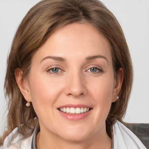 Joyful white young-adult female with medium  brown hair and grey eyes