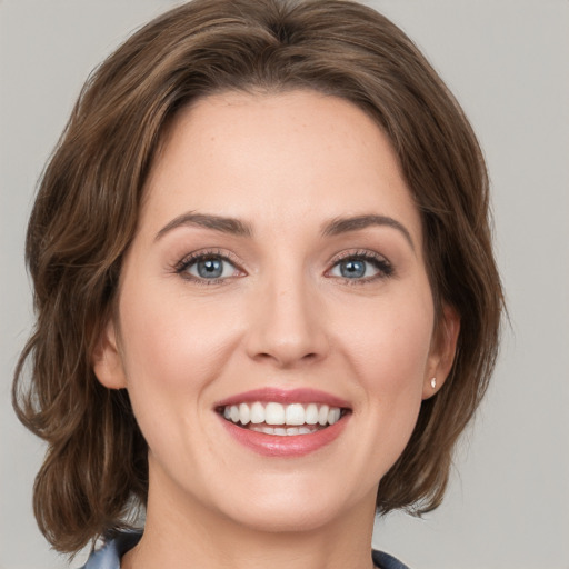 Joyful white young-adult female with medium  brown hair and green eyes