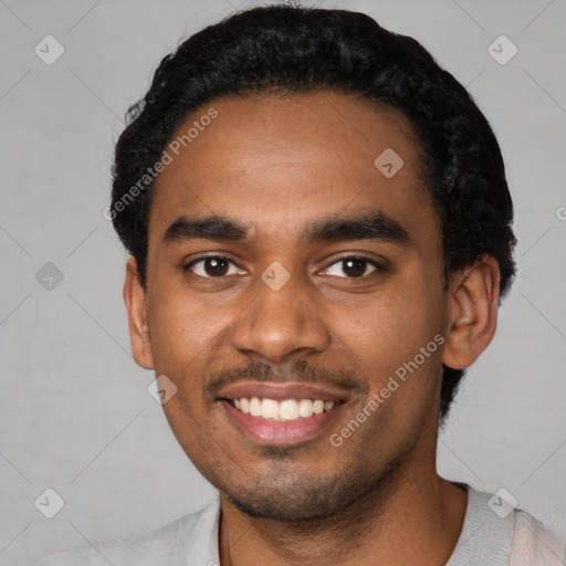 Joyful black young-adult male with short  black hair and brown eyes