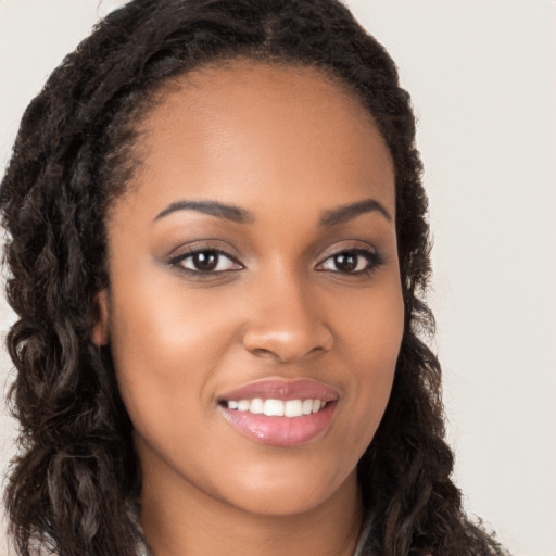 Joyful black young-adult female with long  brown hair and brown eyes