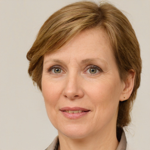 Joyful white adult female with medium  brown hair and green eyes