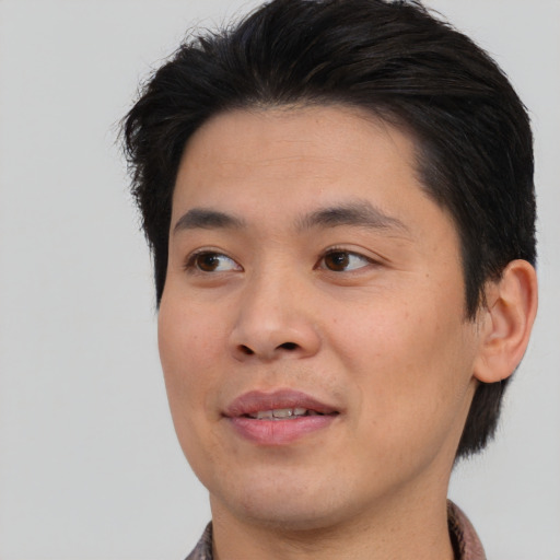 Joyful asian young-adult male with short  brown hair and brown eyes