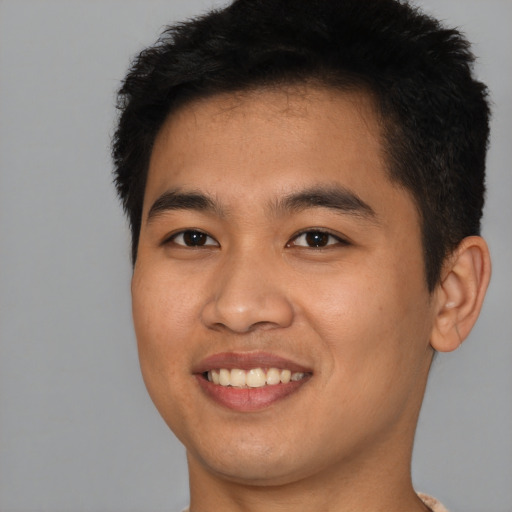 Joyful asian young-adult male with short  brown hair and brown eyes