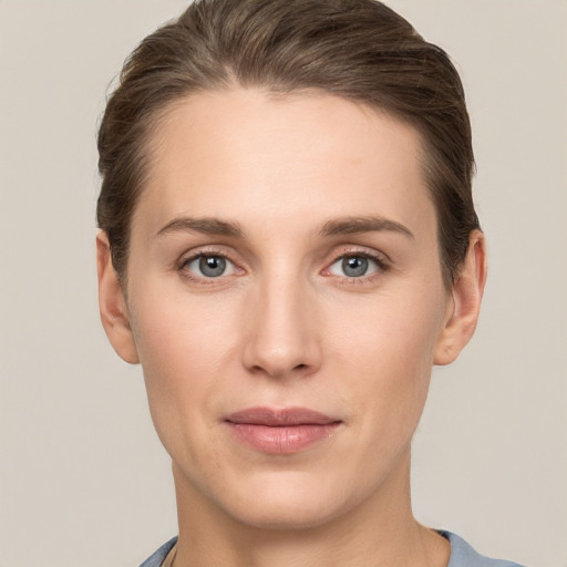 Joyful white young-adult female with short  brown hair and grey eyes