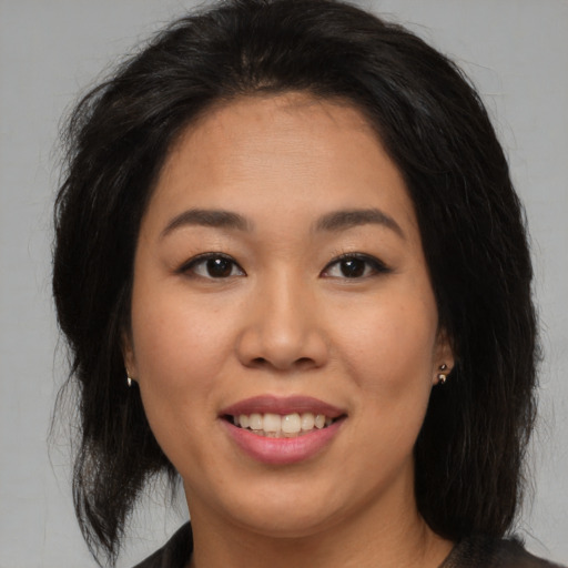 Joyful asian young-adult female with medium  brown hair and brown eyes