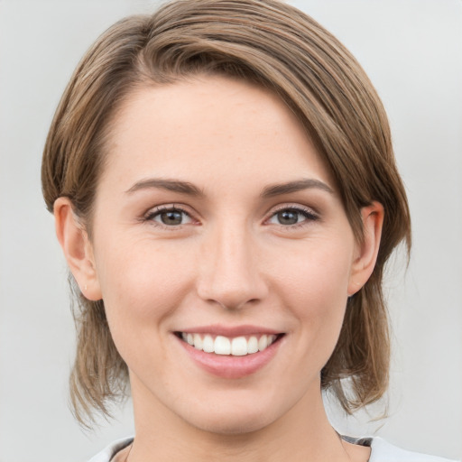 Joyful white young-adult female with medium  brown hair and grey eyes