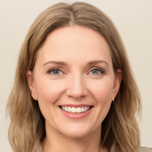 Joyful white young-adult female with medium  brown hair and green eyes