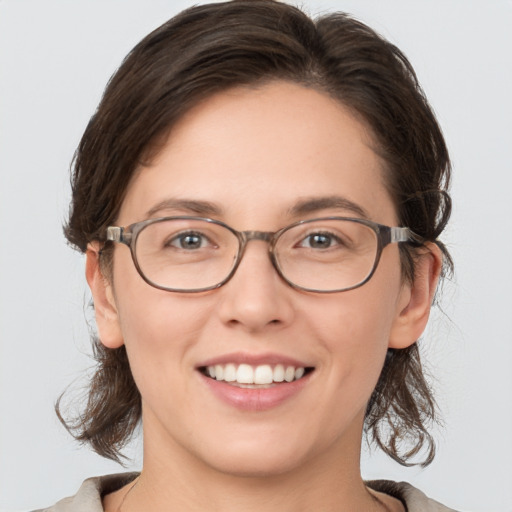 Joyful white young-adult female with medium  brown hair and grey eyes