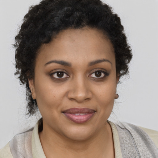 Joyful black young-adult female with short  brown hair and brown eyes