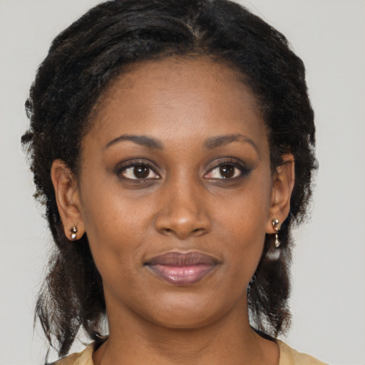 Joyful black young-adult female with long  brown hair and brown eyes