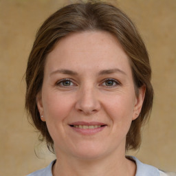 Joyful white adult female with medium  brown hair and grey eyes