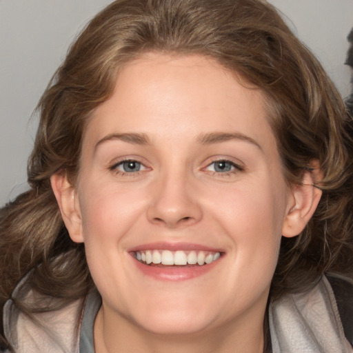 Joyful white adult female with medium  brown hair and grey eyes