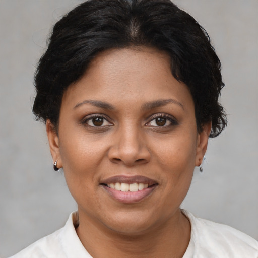 Joyful black young-adult female with short  brown hair and brown eyes