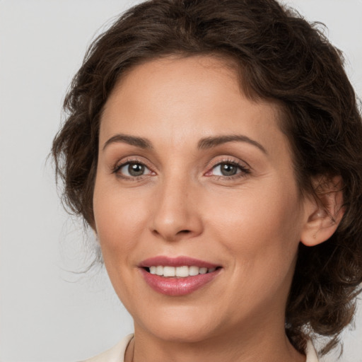 Joyful white adult female with medium  brown hair and brown eyes