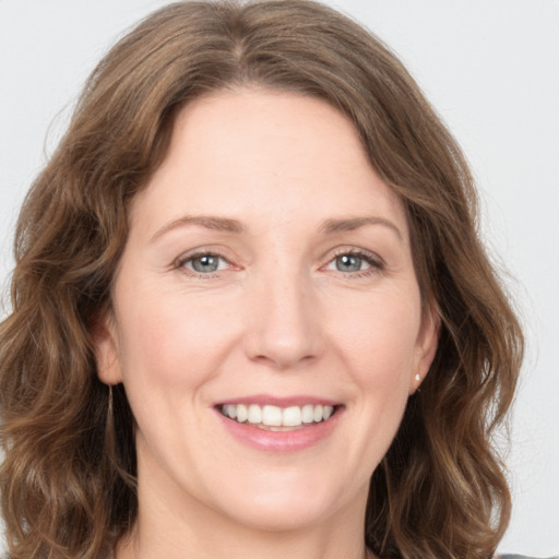 Joyful white young-adult female with medium  brown hair and green eyes