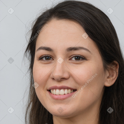 Joyful white young-adult female with long  brown hair and brown eyes