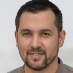 Joyful white adult male with short  brown hair and brown eyes