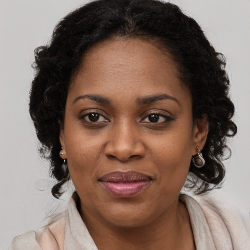Joyful black young-adult female with long  brown hair and brown eyes