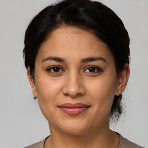 Joyful latino young-adult female with medium  brown hair and brown eyes