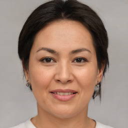 Joyful asian adult female with medium  brown hair and brown eyes