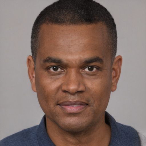 Joyful black adult male with short  brown hair and brown eyes