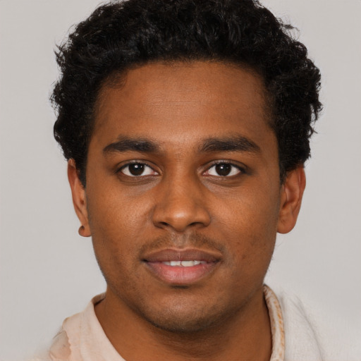 Joyful black young-adult male with short  brown hair and brown eyes