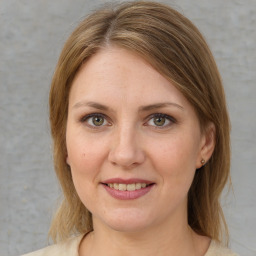 Joyful white adult female with medium  brown hair and green eyes