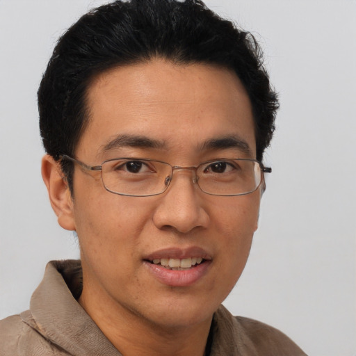 Joyful asian adult male with short  brown hair and brown eyes