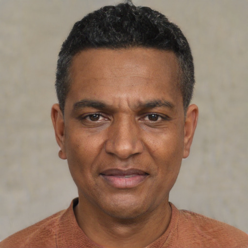 Joyful black adult male with short  black hair and brown eyes