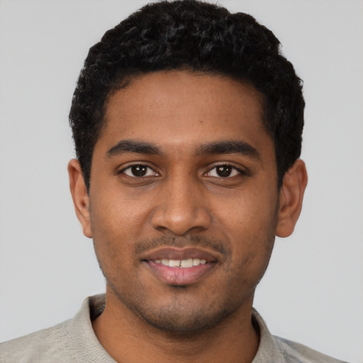 Joyful black young-adult male with short  black hair and brown eyes