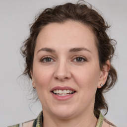 Joyful white young-adult female with medium  brown hair and green eyes