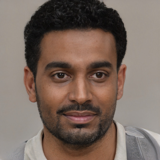 Joyful black young-adult male with short  black hair and brown eyes