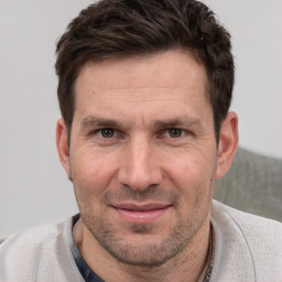 Joyful white adult male with short  brown hair and brown eyes