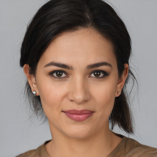 Joyful latino young-adult female with medium  brown hair and brown eyes
