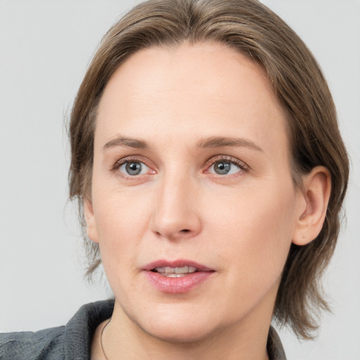 Joyful white young-adult female with medium  brown hair and grey eyes