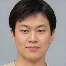 Joyful asian young-adult male with short  brown hair and brown eyes