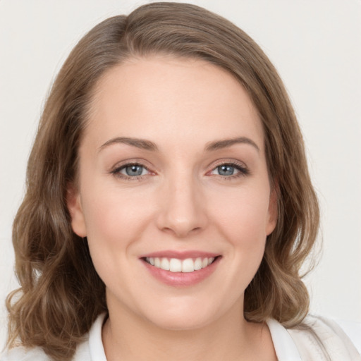 Joyful white young-adult female with medium  brown hair and green eyes