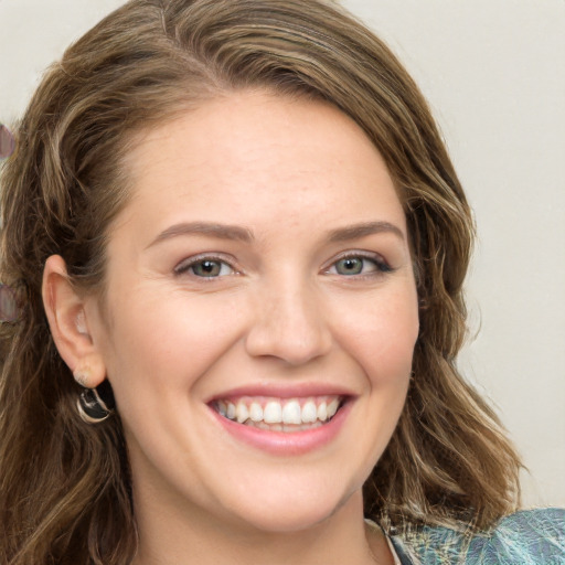 Joyful white young-adult female with long  brown hair and green eyes