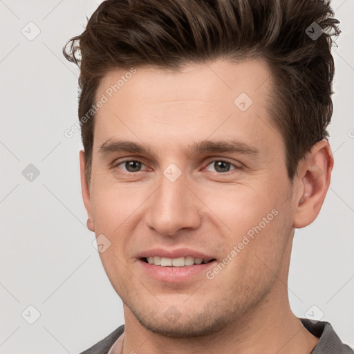 Joyful white young-adult male with short  brown hair and grey eyes