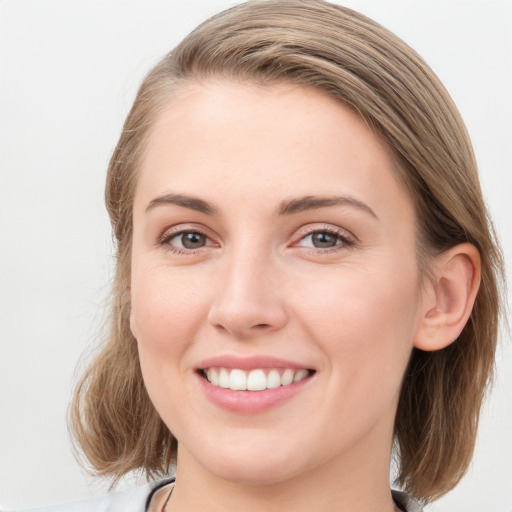 Joyful white young-adult female with medium  brown hair and blue eyes