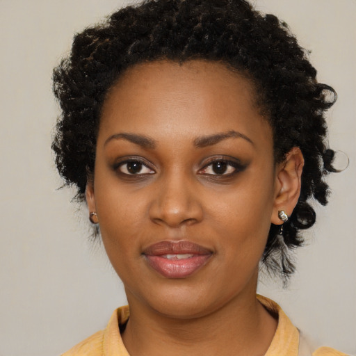 Joyful black young-adult female with short  black hair and brown eyes