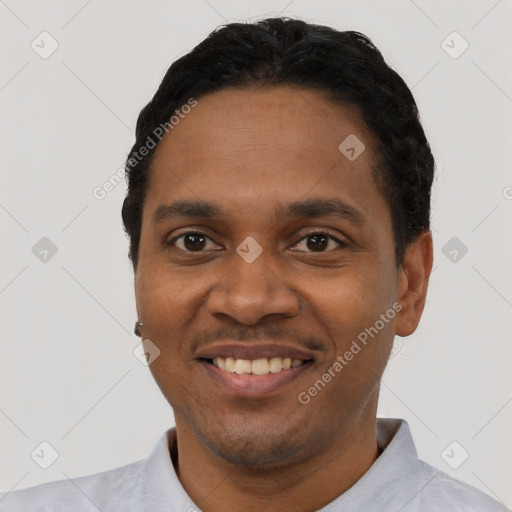 Joyful black young-adult male with short  black hair and brown eyes